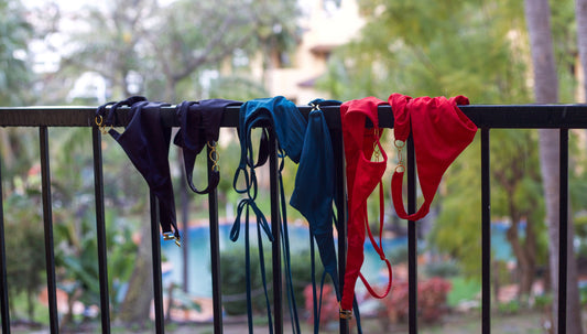 Leah Loves Ivy and Sage Bikinis in Red, Ocean Green and Black Hanging on a Balcony in the Rain