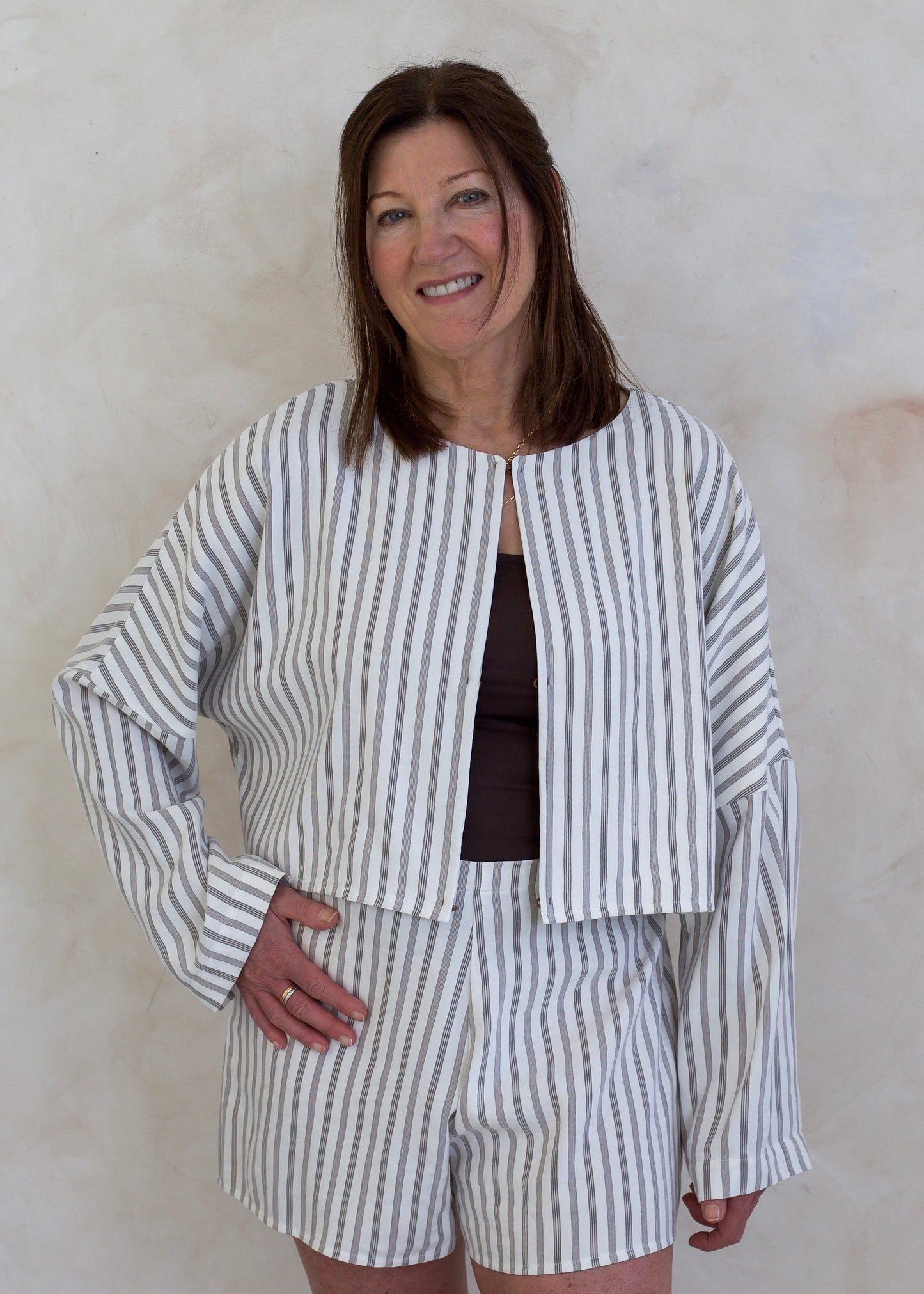 Woman wearing a striped outfit against a plain background