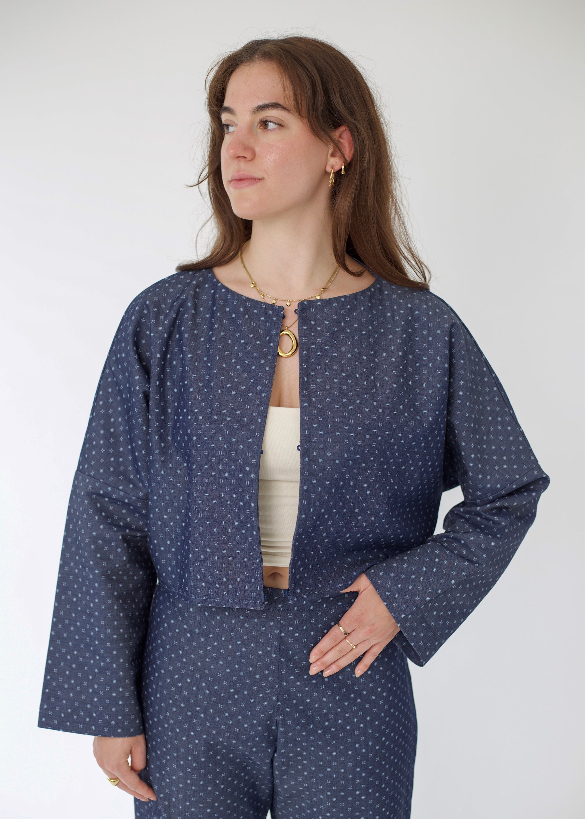 Woman wearing a blue polka dot outfit against a white background