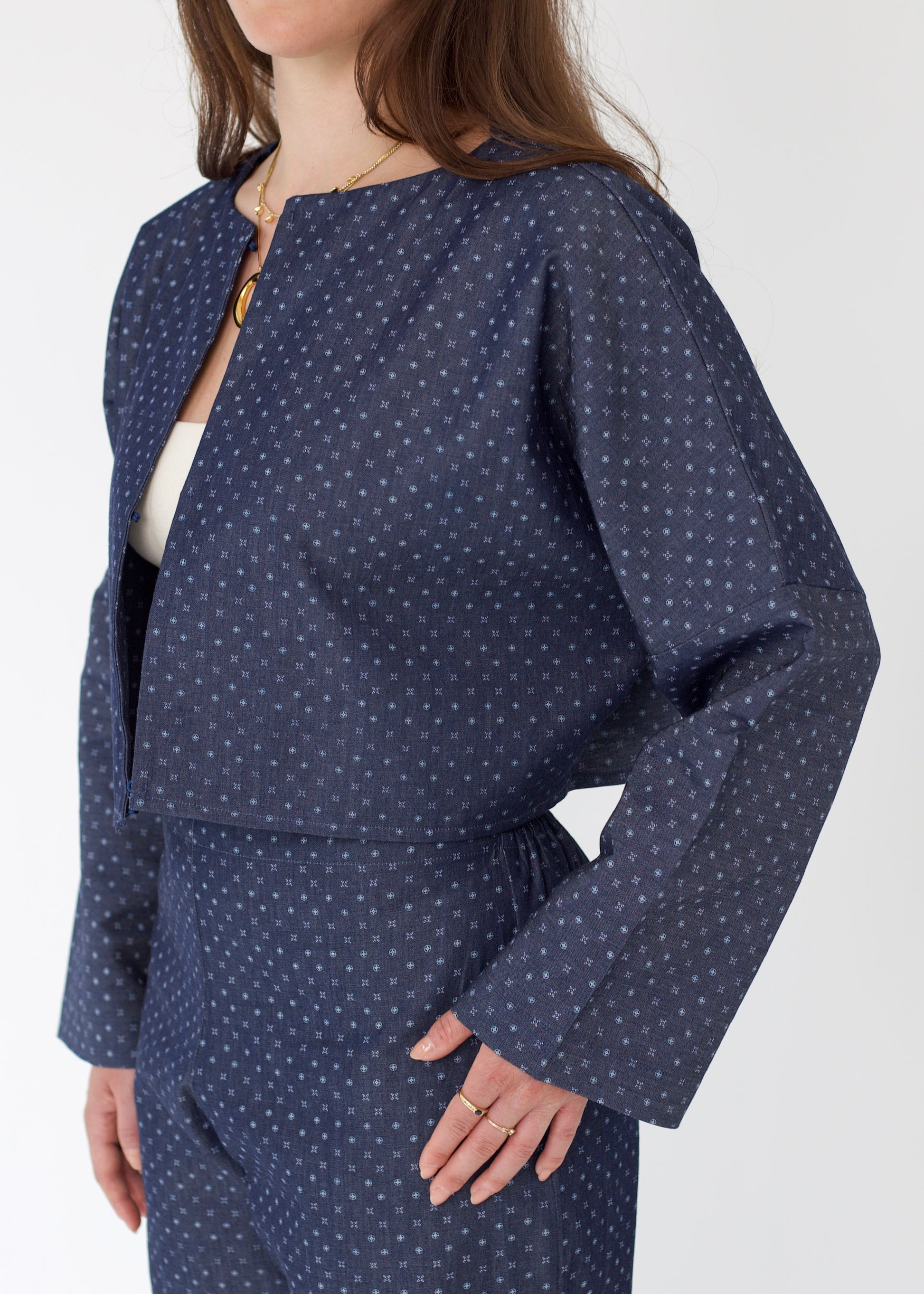 Woman wearing a navy blue polka dot outfit on a white background