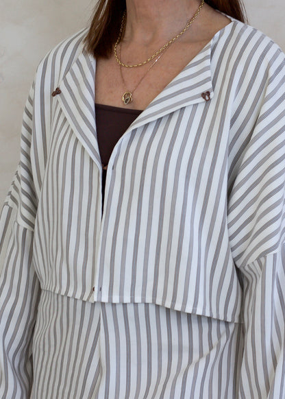 Person wearing a striped outfit with a neutral background
